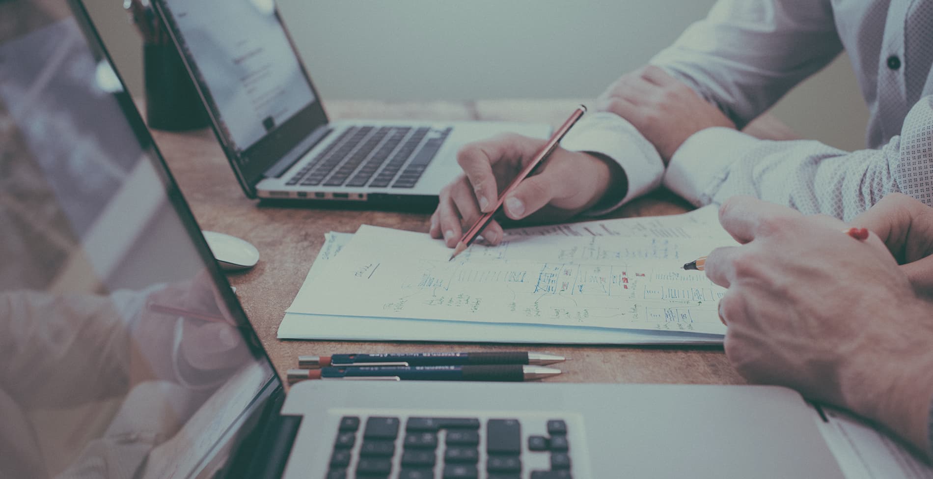 photograph of people using laptop computers and paper to share ideas the way Cokato attorney Tom James does